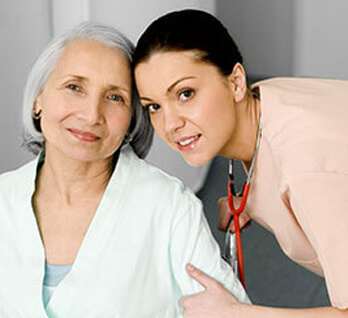Female nurse with stethoscope with hand around arm of woman with gray hair. Female nurse with stethoscope with hand around arm of woman with gray hair.