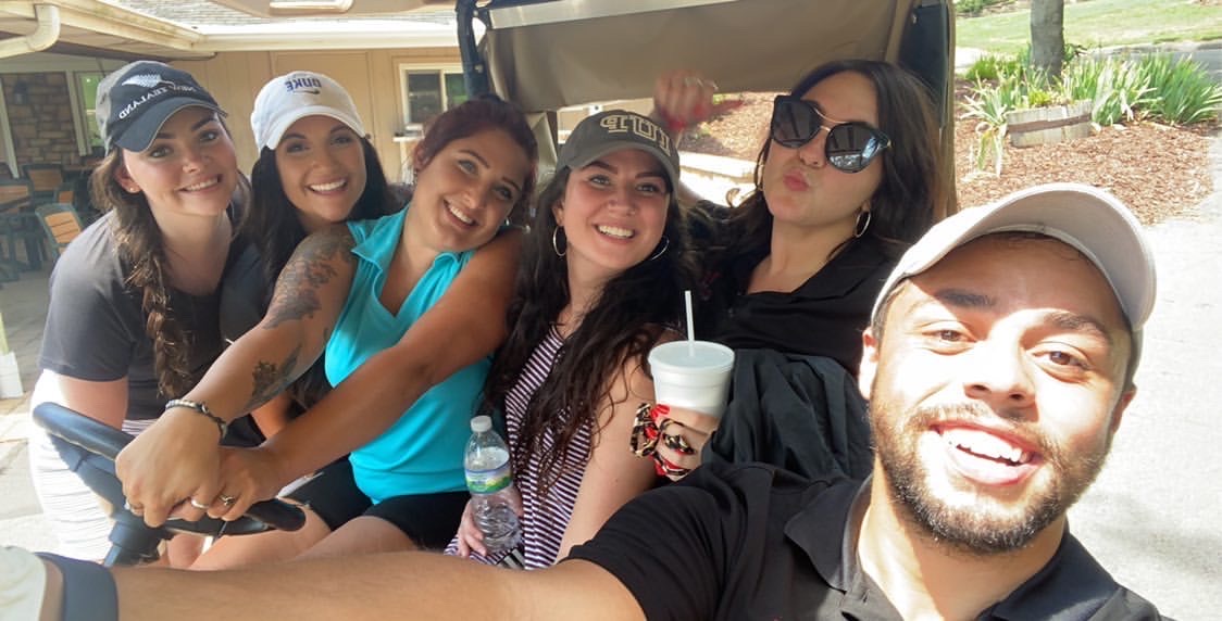 Group posing for picture in golf cart