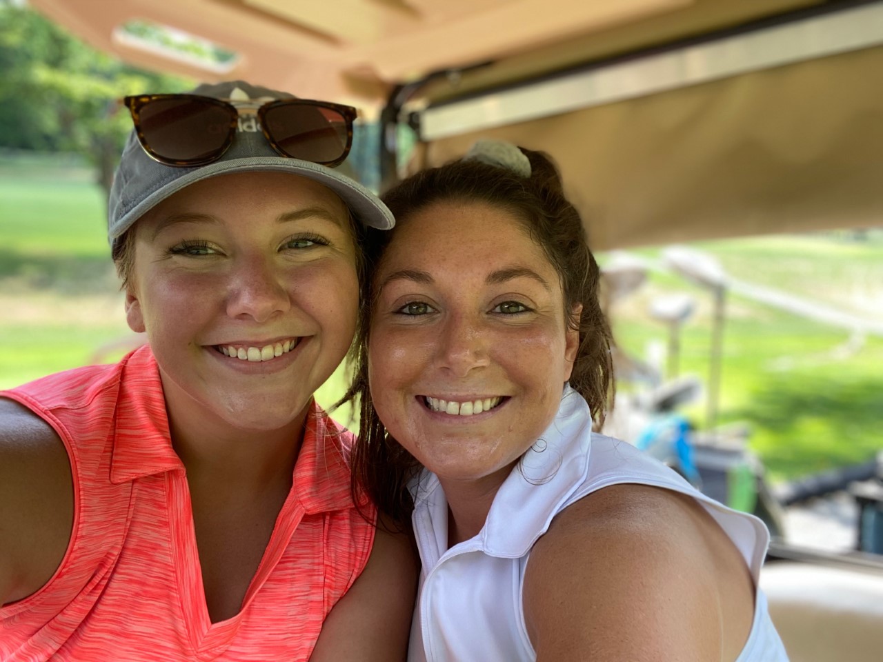 Women posing for picture in golf cart