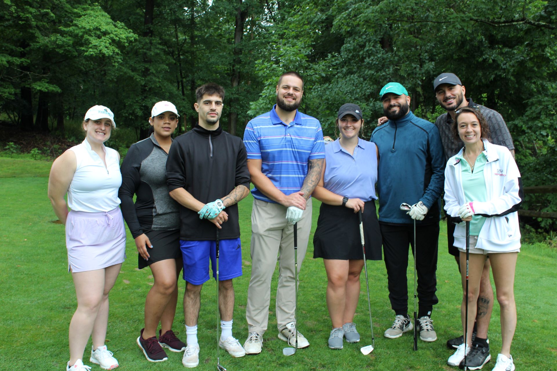A group of golfers pose for a picture on the green at a charity golf outing