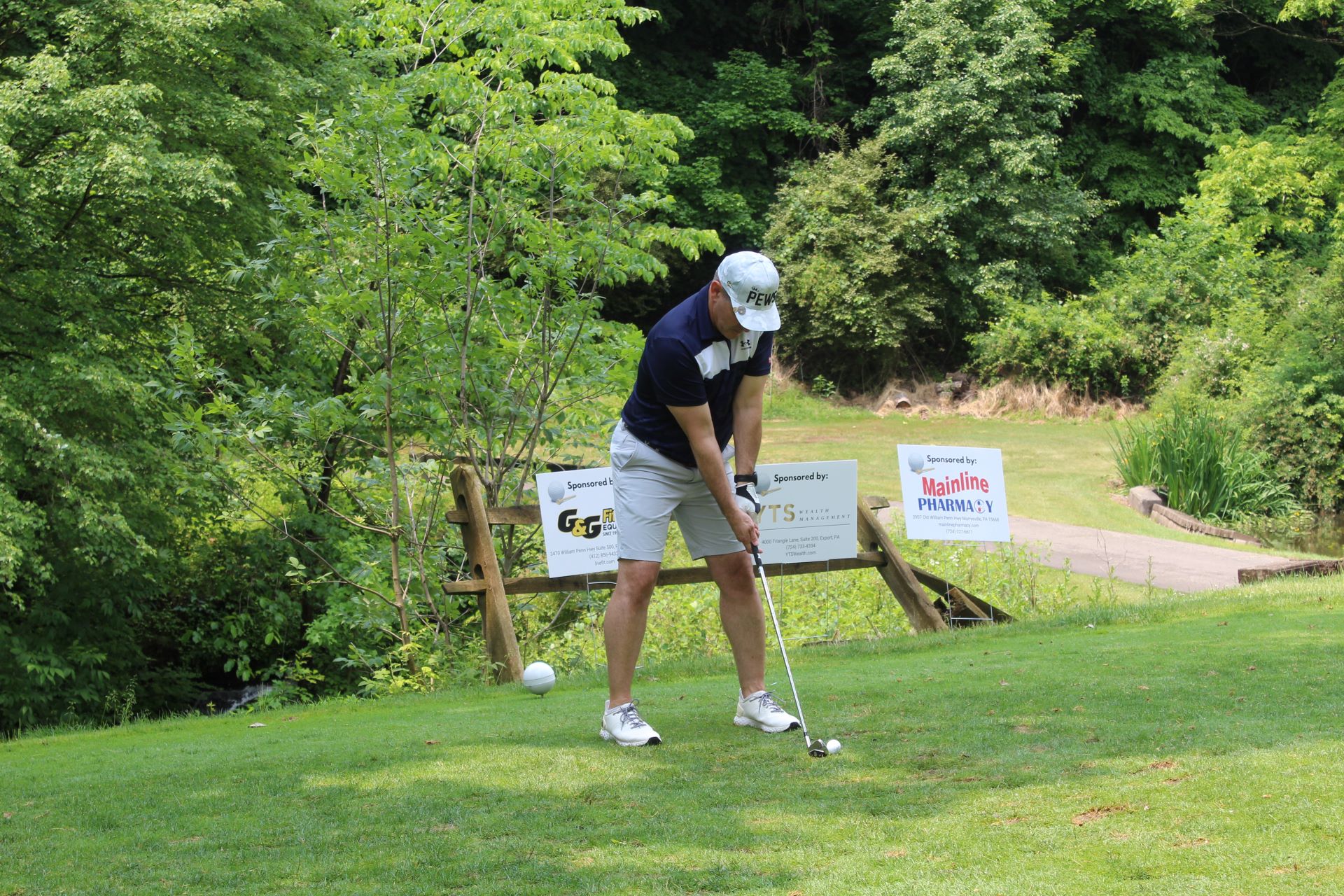 A man lining up his drive at a charity golf outing