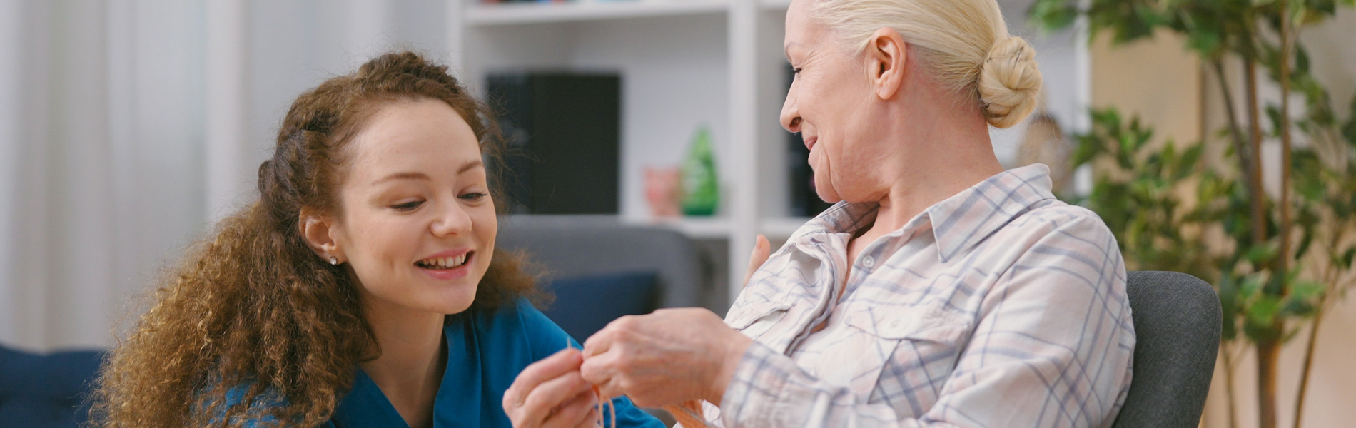 Young home care nurse and elderly woman smiling